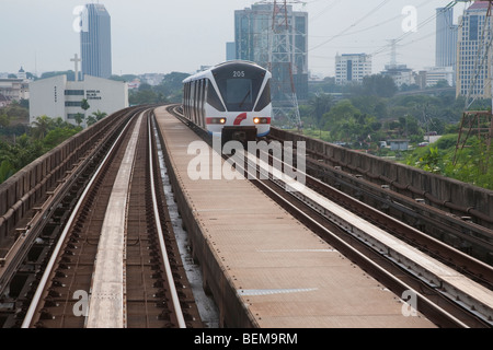 RapidKL treno sulla ferrovia sopraelevata con Kuala Lumpur in background. Kuala Lumpur, Selangor, Malaysia Foto Stock