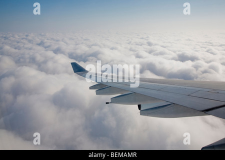 Un'ala di aeroplano sopra le nuvole. Il velivolo è un Airbus A340, operati da Cathay Pacific Airline. Foto Stock