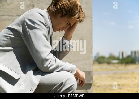 Imprenditore contemplatively tenendo la testa Foto Stock