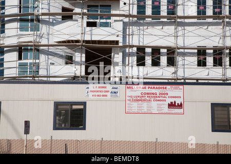 Ponteggio su un impiego misto blocco di appartamenti, un cartello pubblicitario di promuovere i nuovi locali. Millbrae, California, Stati Uniti d'America Foto Stock