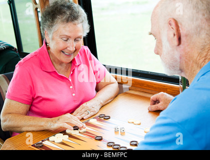 Coppia senior nella cucina del loro motore home giocare a backgammon. Foto Stock