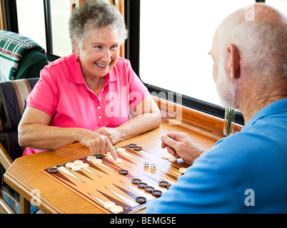Coppia senior gode di un gioco del Backgammon nella loro casa a motore. Foto Stock