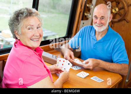 Felice coppia in pensione giocando a carte nella loro casa a motore. Foto Stock
