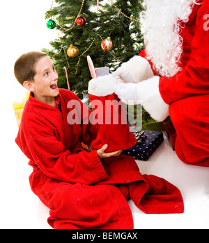 Adorabili poco ragazzo riceve una calza di Natale da Santa Claus. Foto Stock