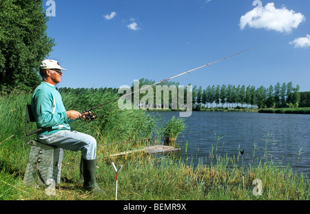 Il pescatore lungo il bordo del lago, Belgio Foto Stock