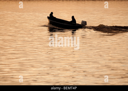 I pescatori che si dirigano verso il mare in un piccolo motoscafo / skiff , Finlandia Foto Stock