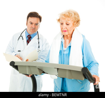 Senior lady passeggiate sul tapis roulant sotto la supervisione del suo medico. Isolato su bianco. Foto Stock