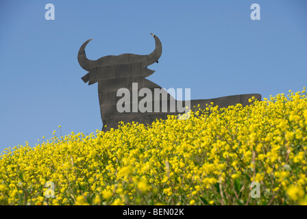 Osborne Bull cielo azzurro fiori gialli simbolo icona della Spagna. Ubicazione Andalucia Foto Stock