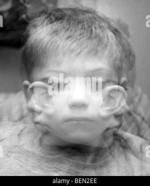 Una tripla esposizione raffigurante un piccolo ragazzo che guarda in tre direzioni diverse Foto Stock