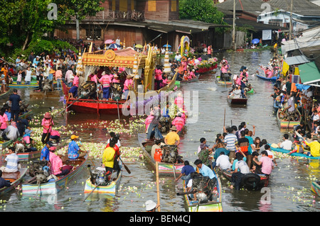 La folla gettano fiori di loto in un'immagine del Buddha al rap Bua Lotus gettando Festival in Thailandia per celebrare la fine del buddismo Foto Stock