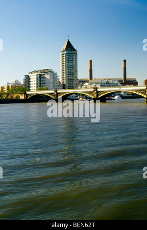 Visualizzazione verticale del Chelsea Harbour Tower e Battersea ponte ferroviario in una bella giornata di blu con il Fulham power station camini Foto Stock