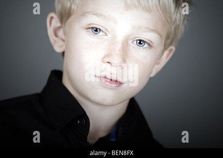 Suggestivo Ritratto di una cute capelli biondo Ragazzo che guarda pensieroso Foto Stock