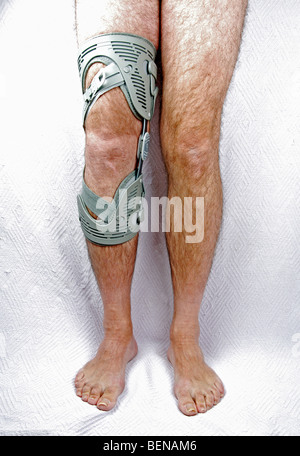 Un uomo che indossa un tutore per ginocchio sulla sua gamba destra Foto Stock