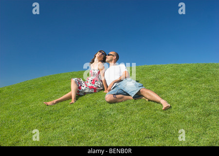 Bella coppia di fidanzati rilassante su un bellissimo campo verde Foto Stock