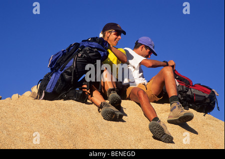 Matura in appoggio sulla roccia con zaini. Foto Stock