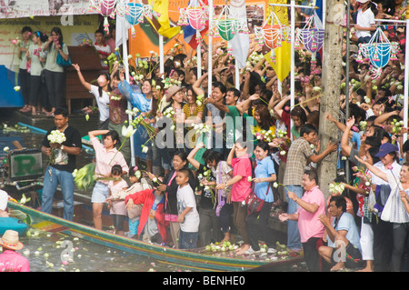 La folla lancia fiori di loto al rap Bua Lotus gettando Festival in Thailandia per celebrare la fine della Quaresima buddista Foto Stock