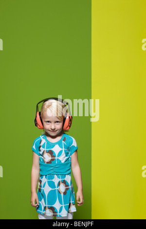 Bambina indossa le cuffie di protezione Foto Stock