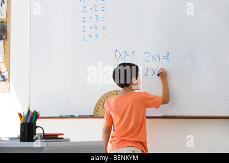 Scuola elementare di lavoro dello studente le equazioni matematiche su whiteboard Foto Stock