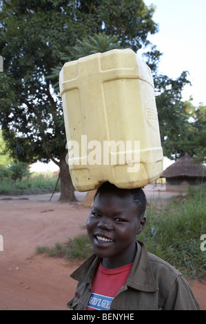 Il SUD SUDAN donna che trasportano l'acqua da una pompa a mano e la mattina presto a Yei. Foto di SEAN SPRAGUE 2008 Foto Stock