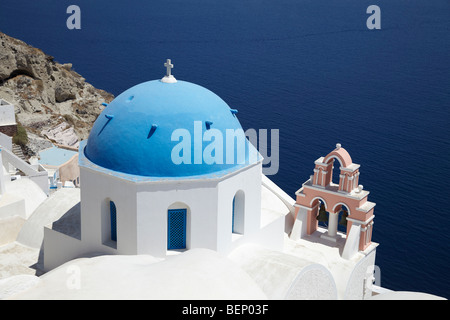 Bianco greco chiesa con cupola blu che si affaccia sul mare, Oia - Santorini, Cicladi, Grecia. Foto Stock