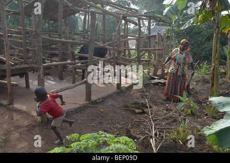 UGANDA madre e figlio tenendo lascia a compost pit Foto Stock