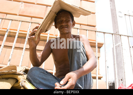 Un senzatetto mendica per denaro al di fuori di un edificio in Brasile Foto Stock