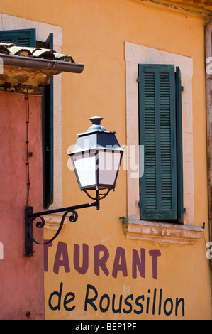 La facciata colorata del ristorante con tendine e lanterna, Roussillon, Provenza, Vaucluse, Provence-Alpes-Côte d'Azur, in Francia Foto Stock