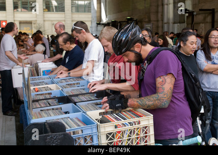 Gli amanti della musica di ordinare attraverso pile e pile di dischi in vinile al Superstar DJ Record Fair di Brooklyn a New York Foto Stock