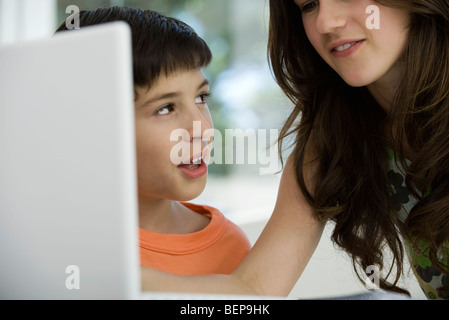 Sorella e fratello minore utilizzando computer portatile insieme Foto Stock