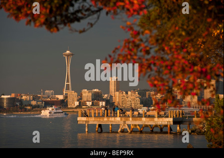 Su una bella cascata di giorno la gente godere la skyline di Seattle e lo Space Needle guardando al di sopra della Baia di Elliott da Alki Beach. Foto Stock