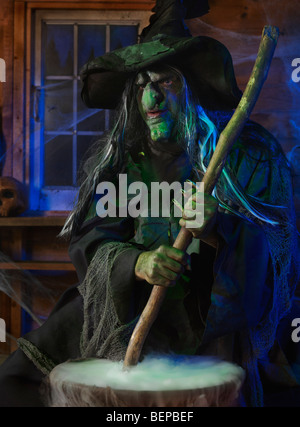 Licenza disponibile a MaximImages.com - spaventa vecchia pozione strega mescolando in un calderone all'interno della sua cabina su Halloween Foto Stock
