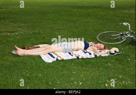 La donna a prendere il sole nel parco Foto Stock