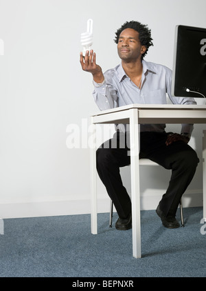 Business man contiene fino eco lampadina Foto Stock