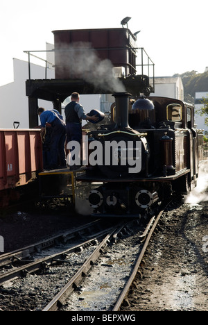 Alimentazione del motore di un treno a vapore a Porthmadog stazione La Ffestiniog Railway, Gwynedd, Galles. Foto Stock