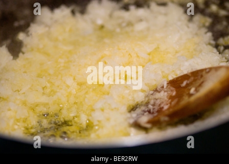 Un trito di cipolle fritte in padella Foto Stock