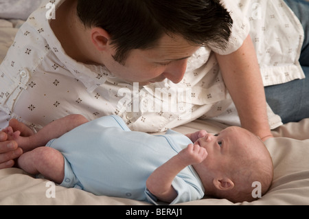 Padre cercando adoringly al neonato boy Foto Stock