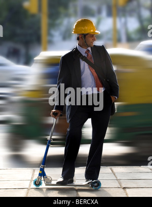 Un uomo su un giocattolo scooter Foto Stock