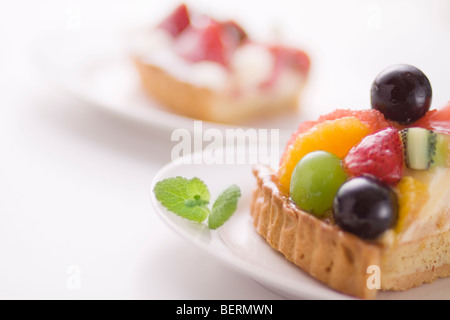 Pezzi di torta su piastre, vicino, sfondo bianco Foto Stock