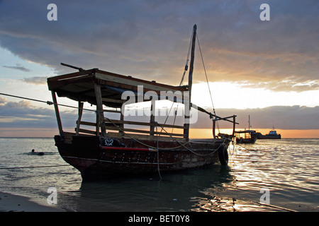 Barche in Oceano Indiano al tramonto nel porto di Stone Town / Stonetown / Mji Mkongwe, Zanzibar, Tanzania Africa orientale Foto Stock