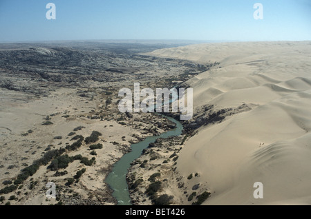 Dune di sabbia tagliato tramite il Cunene River nel deserto del Namib, Namibia settentrionale. L Angola è sul lato sinistro. Foto Stock