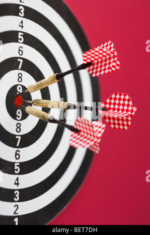 Rosso e bianco e nero scheda dart con tre freccette in bullseye Foto Stock