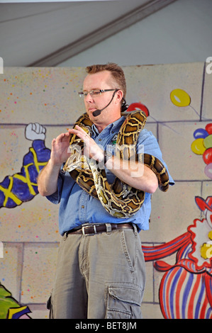 Uomo con python birmano a mostrare degli animali Foto Stock