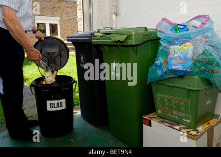 L'uomo il riciclaggio della carta, vetro, plastica, lattine e altri rifiuti in contenitori diversi, Belgio Foto Stock