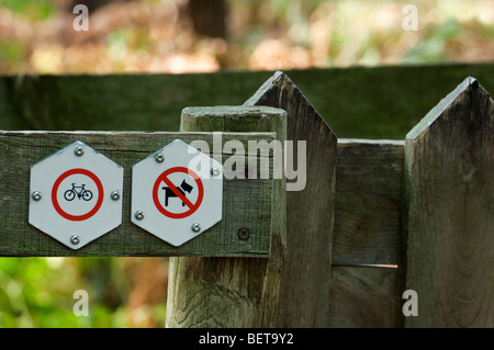 Cartelli di divieto sulla staccionata in legno all ingresso della riserva naturale di vietare l'accesso ai cani e biciclette Foto Stock