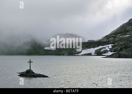 La nebbia sul lago e ospizio per i viaggiatori al Passo del Gran San Bernardo nelle alpi svizzere, Svizzera Foto Stock