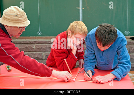 Nonno e nipoti la costruzione di un aquilone insieme Foto Stock