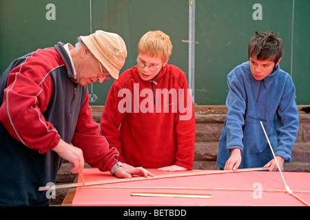 Nonno e nipoti la costruzione di un aquilone insieme Foto Stock