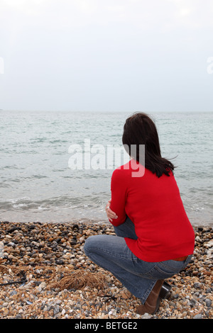 Vista posteriore di slim dai capelli scuri donna che guarda lontano in distanza Foto Stock