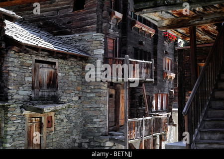 Alley con vecchie case in legno / chalets nel villaggio alpino, Zermatt Valais / Wallis, Visp, alpi svizzere, Svizzera Foto Stock