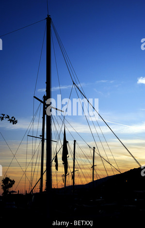 Barche a vela a montanti contro il cielo al tramonto a Kalkan Foto Stock